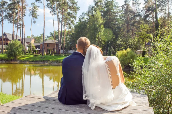 Visão Traseira Recém Casados Sentados Cais Madeira Perto Lago Dia — Fotografia de Stock