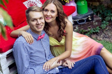 sarılma ve Bahar park, romantik kavramı çimenlerin üzerinde otururken bankta eğilerek şehvetli Çift 