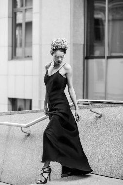 çekici kadın uzun akşam siyah elbise granit merdiven basamaklarında poz 