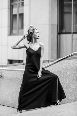 çekici kadın uzun akşam siyah elbise granit merdiven basamaklarında poz 