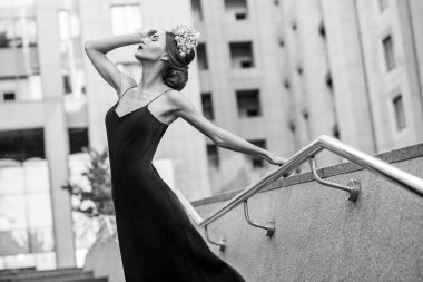 çiçek taç ve Abiye el ile metal korkuluk tutarken poz güzel kadın 