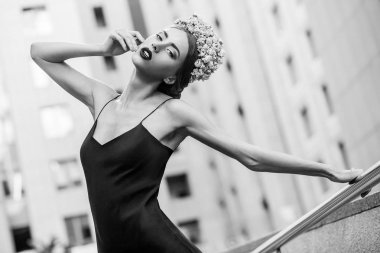 çiçek taç ve Abiye el ile metal korkuluk tutarken poz güzel kadın 