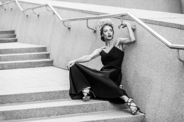 Granit merdiven basamaklarında oturan çekici kadın