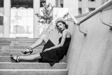Granit merdiven basamaklarında oturan çekici kadın