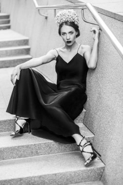 Granit merdiven basamaklarında oturan çekici kadın