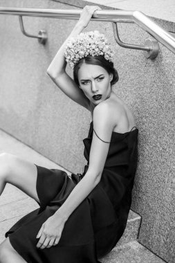 Granit merdiven basamaklarında oturan çekici kadın