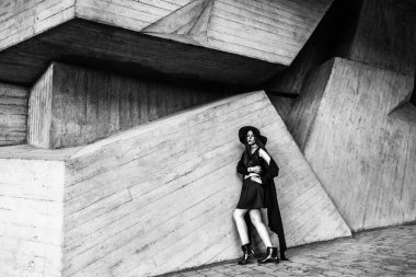 şık giysiler ve karanlık şapka ayakta ahşap inşaat yakınındaki güzel model 