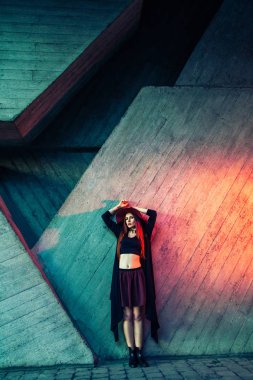 renkli ahşap bina eğilerek yükseltilmiş kollu şık giysiler içinde güzel kadın