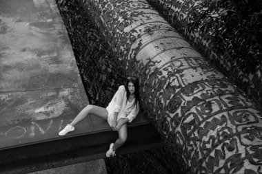 terk edilmiş binaya otururken poz Beyaz giysili çekici kadın 