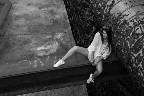 terk edilmiş binaya otururken poz Beyaz giysili çekici kadın 