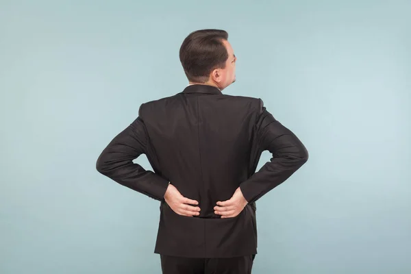Unhappy businessman touching back while having pain in kidneys on light blue background — Stock Image Unhappy Businessman Touching Back While Having Pain Kidneys Light Blue Stock Picture