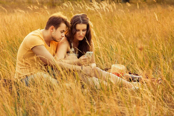 Verliefde Paar Gebruikend Smartphone Zittend Bloemen Veld Herfst Park Warme — Stockfoto