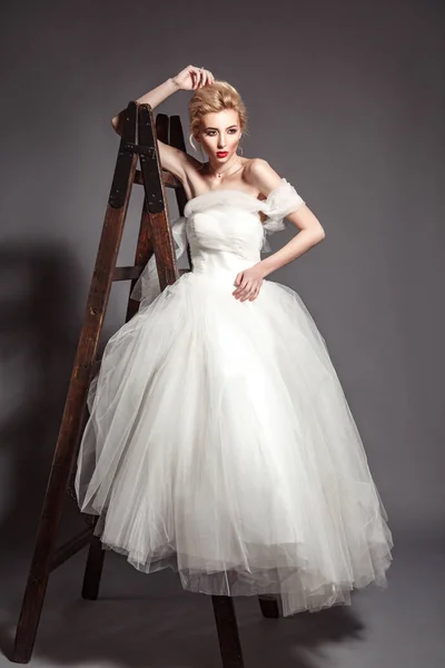 Μόδα ομορφιά Νυφικά γυρίσματα. Όμορφη μόδας νύφη στο γάμο φόρεμα ποζάρει μπροστά από ξυλώδη φόντο. — Φωτογραφία Αρχείου