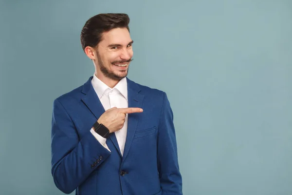 滑稽的人在西装指向在浅蓝色背景 富有和成功的商业人的概念旁边的手指 — 图库照片