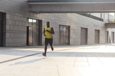 genç adamın sarı renk spor giyim hızlı açık havada spor kavram çalışan giydiğini yerleştirmek 