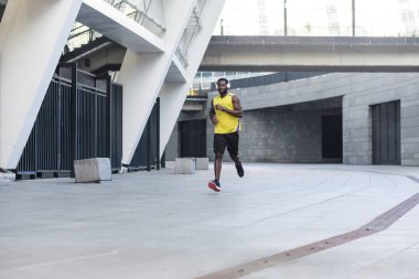 genç adamın sarı renk spor giyim hızlı açık havada spor kavram çalışan giydiğini yerleştirmek 