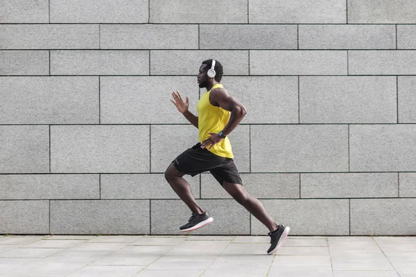 Volwassen Mannelijke Atleet Met Gespierd Lichaam Trainingspak Joggen Tegen Grijze — Stockfoto