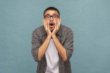 Rahat tarzı kameraya üzerinde mavi arka plan açık ağız ile seyir siyah gözlüklü sakallı hayran yakışıklı adam portresi