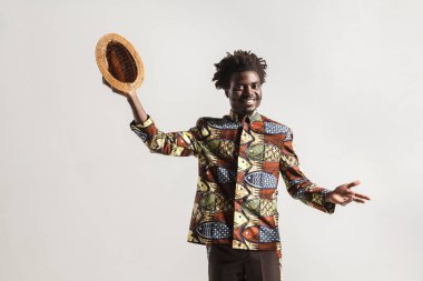 Pozitif Afro-Amerikan modeli gri arka plan üzerinde şapkalı el kadar yükselterek