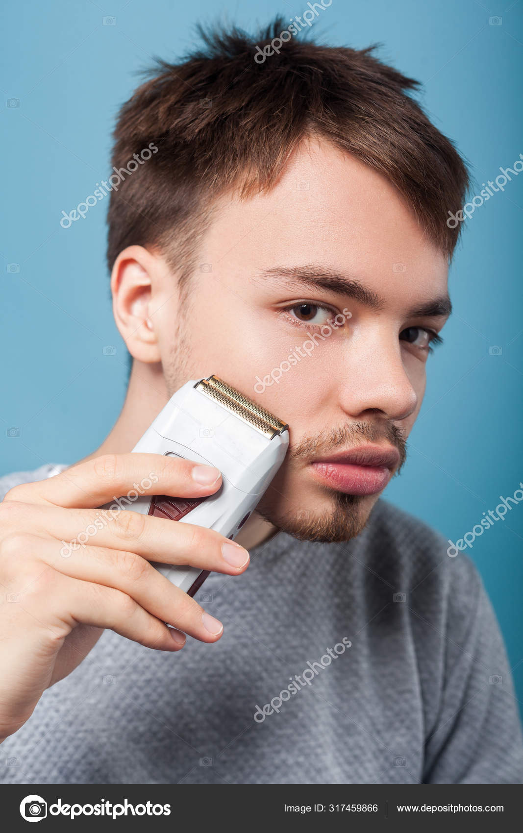 Portrait of handsome brunette man removing facial hair using epi Stock  Photo by ©khosrork 317459866