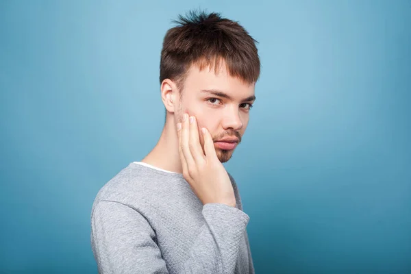 Portrait of young brunette man touching bristle on his cheek, lo — Stock Photo, Image