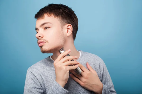 Side view of concentrated brunette man shaving neck, isolated on — Stock Photo, Image