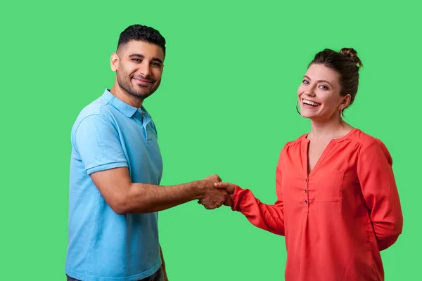 Retrato de encantadora pareja joven en ropa casual de pie y sacudida —  Fotos de Stock