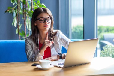 Ciddi, otoriter, şık, esmer bir kadının portresi.