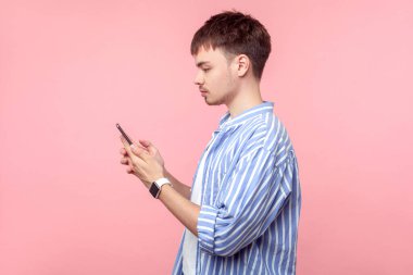 Ciddi kahverengi saçlı, elinde akıllı telefon tutan adamın yan görüntüsü. izole et