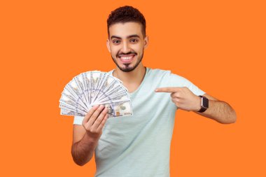 Şanslı esmer adamın portresi dolar banknotlarını işaret ediyor.