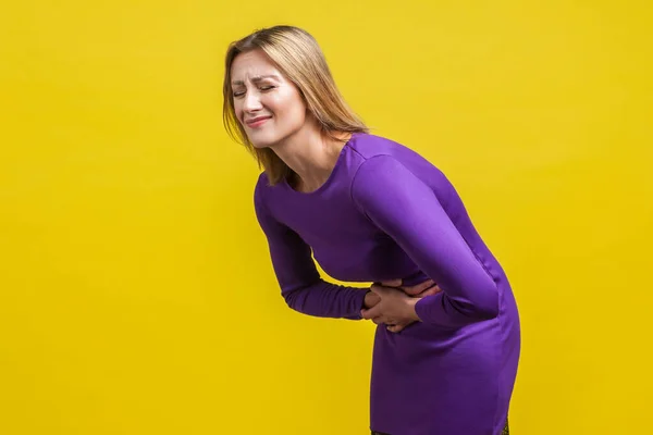 Portrét nezdravé ženy v tísni, svírající si břicho — Stock fotografie