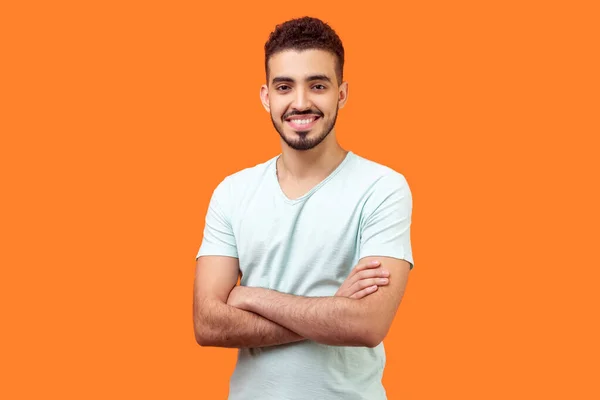 Retrato de homem morena bonito positivo de pé com cruzado — Fotografia de Stock