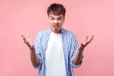 What do you want? Portrait of irritated angry brown-haired man with small beard and mustache in casual striped shirt gesturing why, looking furious. indoor studio shot isolated on pink background clipart