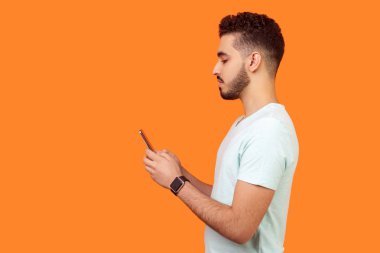 Cep telefonu kullanan esmer bir adamın yan görüntüsü. boş eş