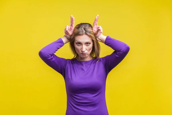 Retrato de mulher valentão ameaçando e mostrando sinal de chifre de touro . — Fotografia de Stock