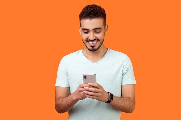 Retrato de hombre morena alegre usando el teléfono celular y sonriendo, r — Foto de Stock