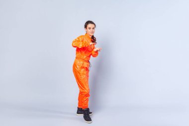 Hip hop hareketi yapan neşeli genç kızın uzun bir görüntüsü.,