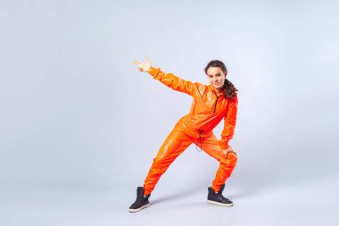 Hip-hop ve poin yapan enerjik genç kızın uzun bir görüntüsü.