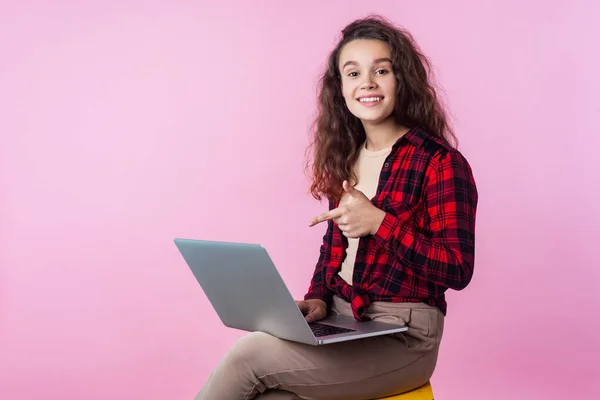 Muotokuva innoissaan teini tyttö osoittaa laptop ja hymyilee — kuvapankkivalokuva