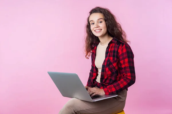 Portrett av positiv smart tenåringsjente som skriver på bærbar tastatur – stockfoto