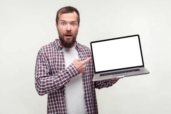 Şok olmuş sakallı bir adamın elinde dizüstü bilgisayarı olan ve e 'yi gösteren portresi. — Stok fotoğraf