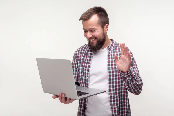 Hi! Portrait of positive bearded man waving hand at laptop, maki — Stock Photo, Image