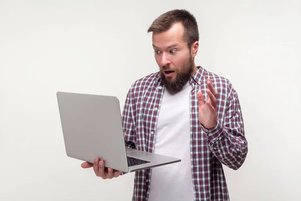 Portret van gefrustreerde man met baard verwijdert de hand van laptop keyb — Stockfoto