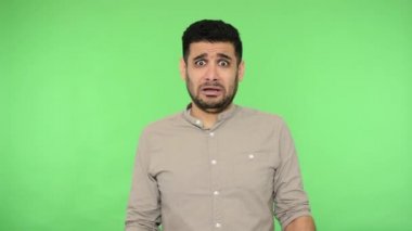 Hayır, lütfen. Korkuyorum! Paniklemiş gömlekli, korkudan ölmüş gibi görünen, kendini savunmak için avuç içi kaldıran, ağlamaya korkan, fobi konsepti olan bir adam. Stüdyo içi çekim, yeşil arka plan, krom anahtar.