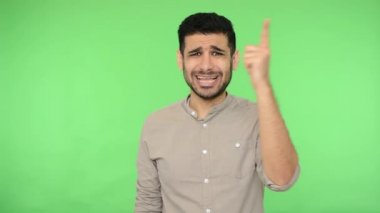 Yalan jesti. Gömlekli hoşnutsuz bir adam burnuna dokunuyor ve yalancı olduğunu söylüyor, kamerayı işaret ediyor, hayal kırıklığına uğramış bir ifadeyle suçluyor. Stüdyo çekimi, yeşil arkaplan, krom anahtar