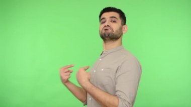 Ben buyum! Gömleği tüylü kibirli esmer adam kendini gösteriyor, kameraya kibirli egoist bakıyor, kendinden emin ve gururlu hissediyor. Stüdyo içi çekim, yeşil arka plan, krom anahtar.