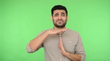 Gömleği tüylü, esmer, yorgun bir adam. Mola verme hareketi yapıyor, yalvarıyor ve suçlu görünüyor. Biraz daha zamana ihtiyacım olduğunu söylüyor. Stüdyo içi çekim, yeşil arka plan, krom anahtar.