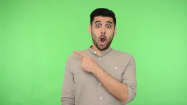 Vay canına, şuraya bak! Fotokopi alanını gösteren tişörtlü adam şaşırmış görünüyor, şaşırmış görünüyor, reklam metni ya da ürün için reklam alanı gösteriyor. İç mekan stüdyo çekimi, kroma anahtarı.