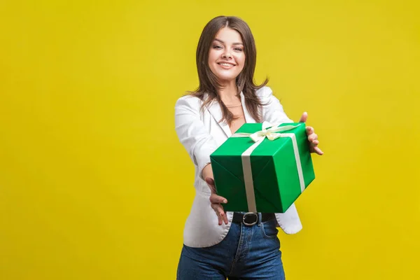 Take this present. Portrait of generous brunette woman holding o