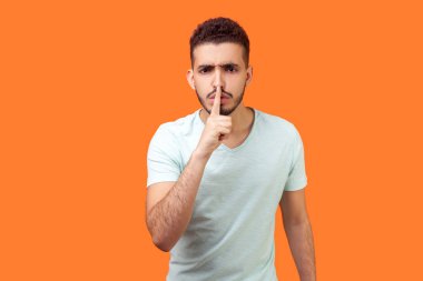 Sessiz olun lütfen! Esmer adamın ciddi portresi.